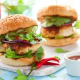 Deliciosa hamburguesa de pollo con pepino, cebolla morada y cilantro fresco. Un toque picante con chiles rojos.