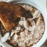Delicioso porridge de avena con pera, coco rallado y semillas de chía. Un desayuno saludable y nutritivo.