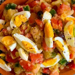 Ensalada campera con patatas, huevos duros, tomate, pimiento y aceitunas. Ingredientes frescos y sabrosos.