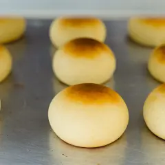 Pan de bono recién horneados, dorados y esponjosos, listos para disfrutar.