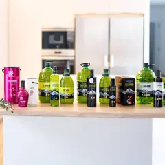 Variedad de botellas y latas de aceite de oliva virgen extra Les Cabanes en una cocina.