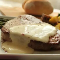 Jugosa ternera en salsa cremosa, acompañada de espárragos y patatas asadas. Un plato principal delicioso.