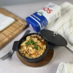Delicioso arroz con bacalao servido en cazuela negra, listo para disfrutar.