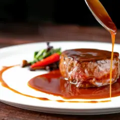 Un filete jugoso bañado en una rica salsa, una de las mejores salsas para carnes, servido con guarnición.