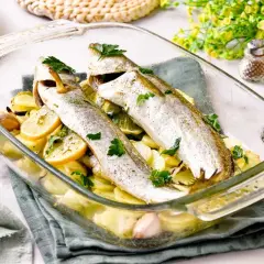 Pescadilla al horno con patatas, limón y ajo, recién salida del horno. Un plato sencillo y delicioso.