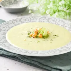 Crema de apio suave y reconfortante, decorada con trocitos de apio fresco y garbanzos crujientes.