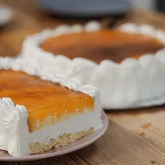 Dos deliciosas tartas San Marcos, una rectangular y otra redonda, cubiertas de crema y glaseado dorado, listas para disfrutar.