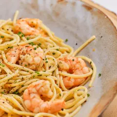 Espaguetis con gambas, un plato delicioso y fácil de preparar. La pasta se mezcla con gambas jugosas y se espolvorea con cebollino fresco.