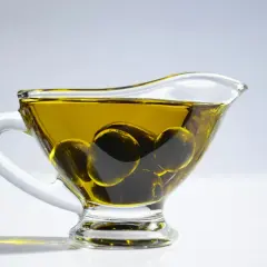 Aceite de oliva para el pelo en una salsera de cristal con aceitunas. Un ingrediente natural para un cabello radiante.