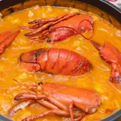 Arroz caldoso con bogavante, un plato delicioso y reconfortante, con trozos de bogavante enteros y jugosos en una salsa cremosa.