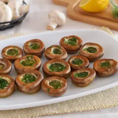 Champiñones a la plancha, dorados y rellenos de perejil fresco, listos para disfrutar.