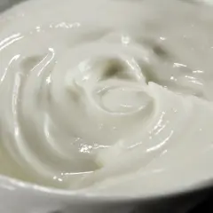 Textura cremosa y suave de alioli con leche, con remolinos que invitan a probarlo.