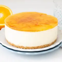 Deliciosa tarta de naranja con cobertura brillante y trozos de naranja. Perfecta para un postre refrescante.