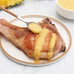 Chuleta de cerdo servida con una deliciosa salsa de piña, que realza su sabor.
