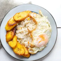 Plato de arroz a la cubana con huevo frito y plátanos maduros fritos.