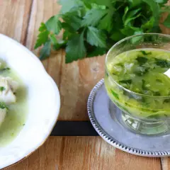 Pescado blanco bañado en una deliciosa salsa verde, con un cuenco de la misma salsa al lado.