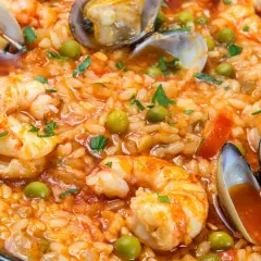 Arroz con marisco, un plato vibrante con gambas, mejillones y guisantes, listo para ser disfrutado.
