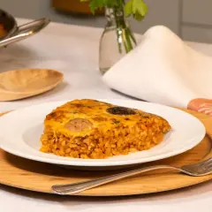 Un delicioso trozo de arroz con costra, con su capa dorada y crujiente, servido en un plato blanco.