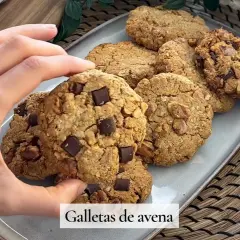 Mano tomando una galleta de avena con trozos de chocolate. Deliciosas galletas de avena caseras.