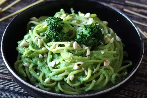 Deliciosa pasta con brócoli cremoso y trocitos de frutos secos, un plato vibrante y nutritivo.