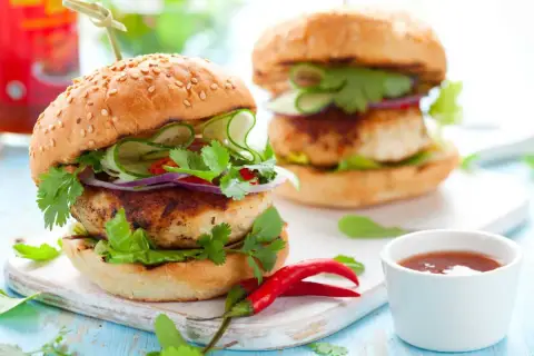 Deliciosa hamburguesa de pollo con pepino, cebolla morada y cilantro fresco. Un toque picante con chiles rojos.