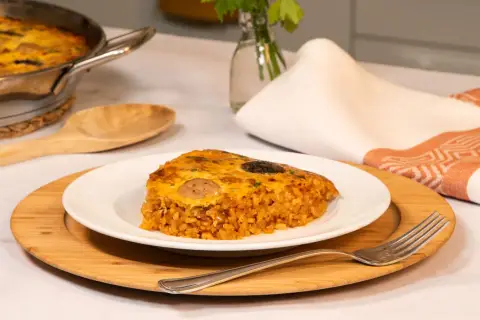 Un delicioso trozo de arroz con costra, con su capa dorada y crujiente, servido en un plato blanco.
