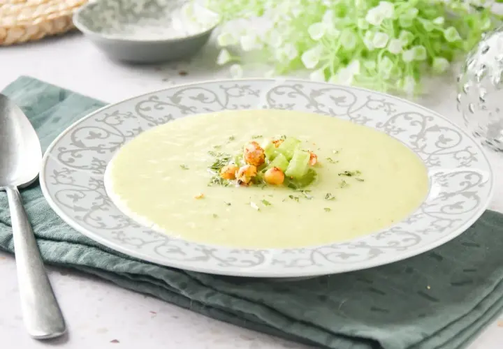 Crema de apio suave y reconfortante, decorada con trocitos de apio fresco y garbanzos crujientes.