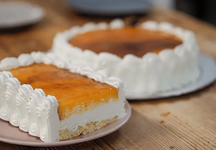 Dos deliciosas tartas San Marcos, una rectangular y otra redonda, cubiertas de crema y glaseado dorado, listas para disfrutar.