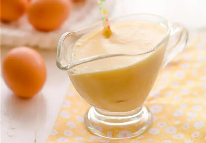 Crema pastelera suave y sedosa, lista para usar, hecha con Thermomix. Huevos frescos en el fondo.