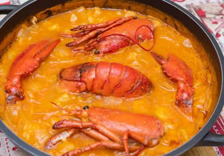 Arroz caldoso con bogavante, un plato delicioso y reconfortante, con trozos de bogavante enteros y jugosos en una salsa cremosa.