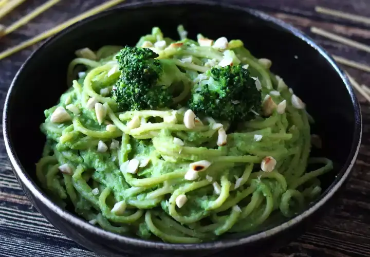 Deliciosa pasta con brócoli cremoso y trocitos de frutos secos, un plato vibrante y nutritivo.