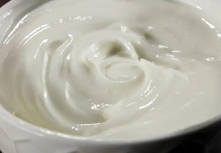 Textura cremosa y suave de alioli con leche, con remolinos que invitan a probarlo.