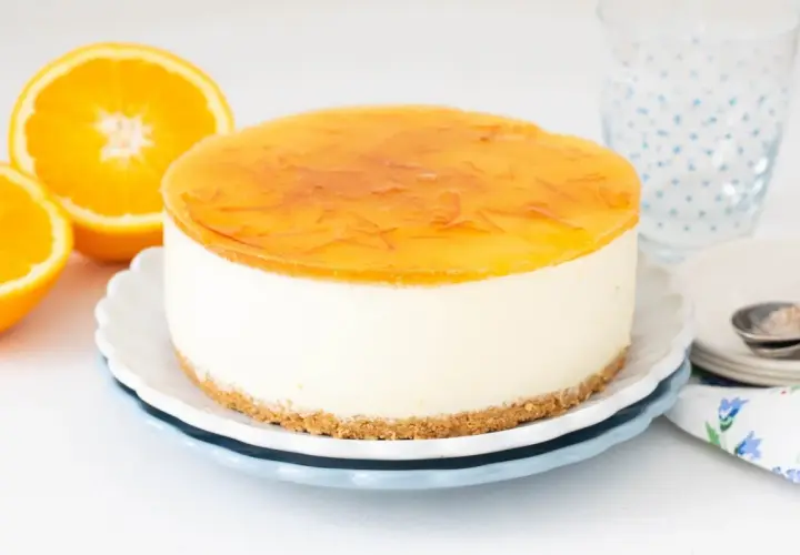 Deliciosa tarta de naranja con cobertura brillante y trozos de naranja. Perfecta para un postre refrescante.