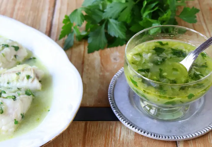 Pescado blanco bañado en una deliciosa salsa verde, con un cuenco de la misma salsa al lado.
