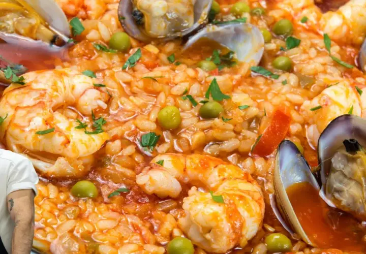 Arroz con marisco, un plato vibrante con gambas, mejillones y guisantes, listo para ser disfrutado.