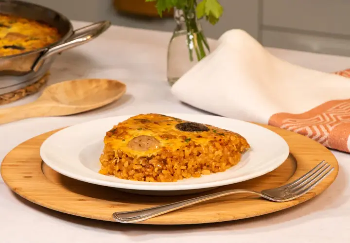 Un delicioso trozo de arroz con costra, con su capa dorada y crujiente, servido en un plato blanco.