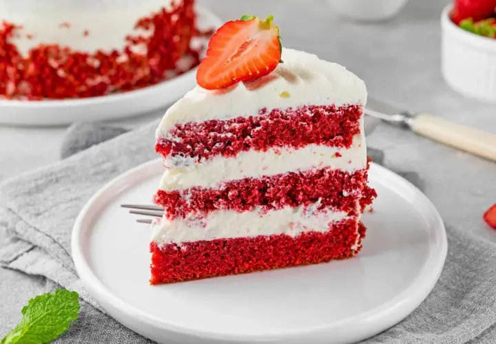 Deliciosa tarta red velvet en capas, cubierta con crema y fresa. Un postre irresistible.