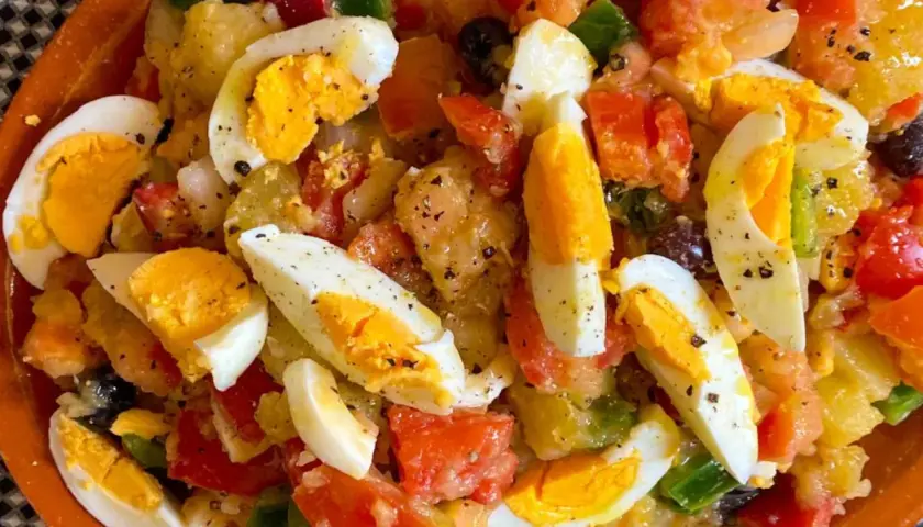 Ensalada campera con patatas, huevos duros, tomate, pimiento y aceitunas. Ingredientes frescos y sabrosos.
