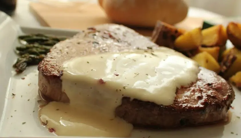 Jugosa ternera en salsa cremosa, acompañada de espárragos y patatas asadas. Un plato principal delicioso.