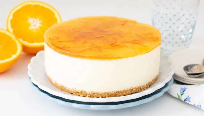 Deliciosa tarta de naranja con cobertura brillante y trozos de naranja. Perfecta para un postre refrescante.