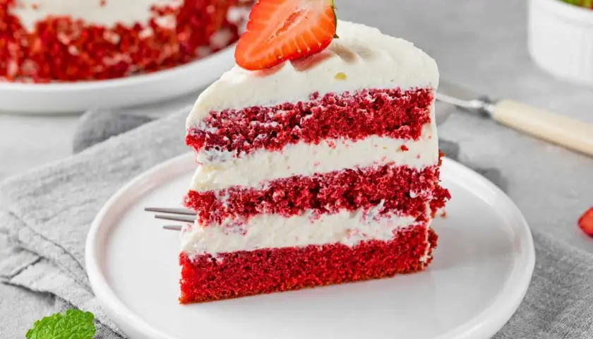 Deliciosa tarta red velvet en capas, cubierta con crema y fresa. Un postre irresistible.