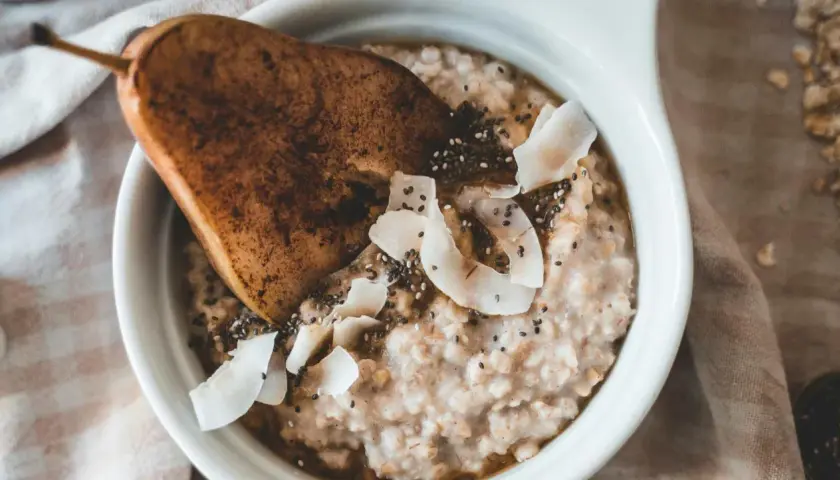 Delicioso porridge de avena con pera, coco rallado y semillas de chía. Un desayuno saludable y nutritivo.