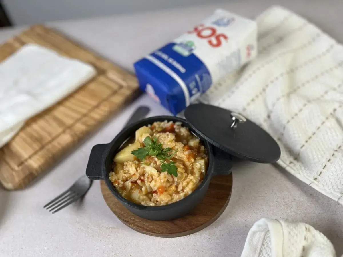 Delicioso arroz con bacalao servido en cazuela negra, listo para disfrutar.