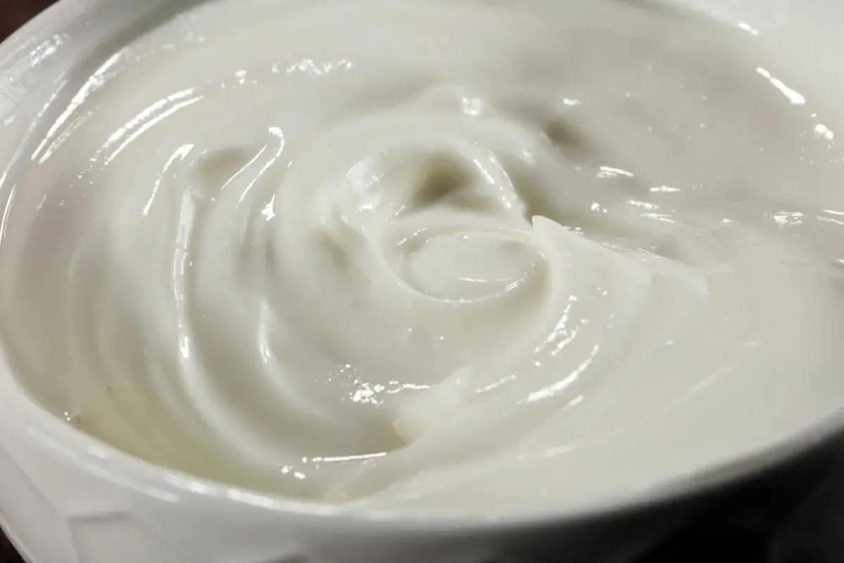 Textura cremosa y suave de alioli con leche, con remolinos que invitan a probarlo.
