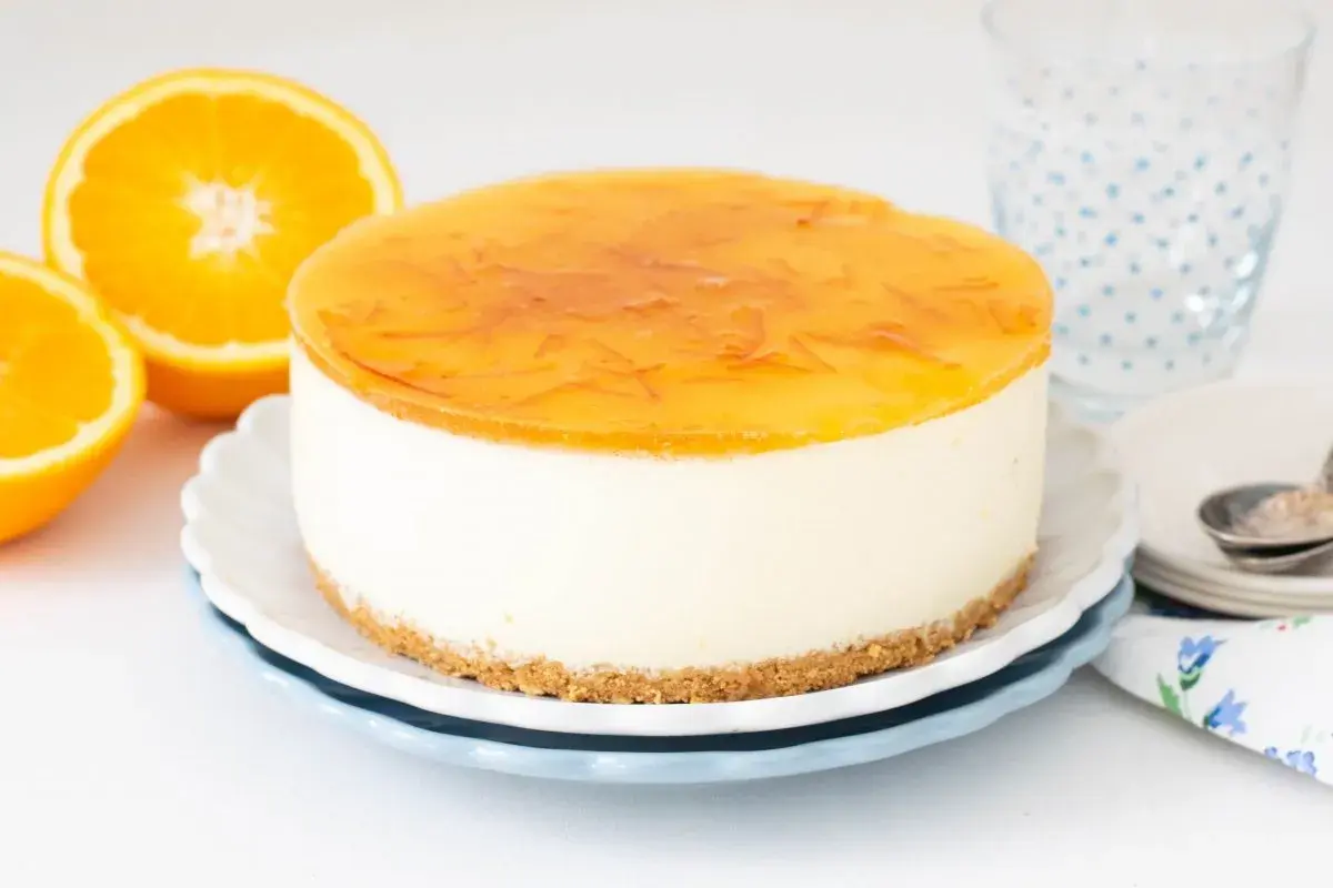 Deliciosa tarta de naranja con cobertura brillante y trozos de naranja. Perfecta para un postre refrescante.