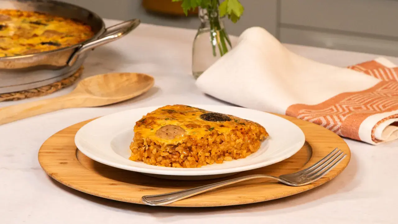 Un delicioso trozo de arroz con costra, con su capa dorada y crujiente, servido en un plato blanco.