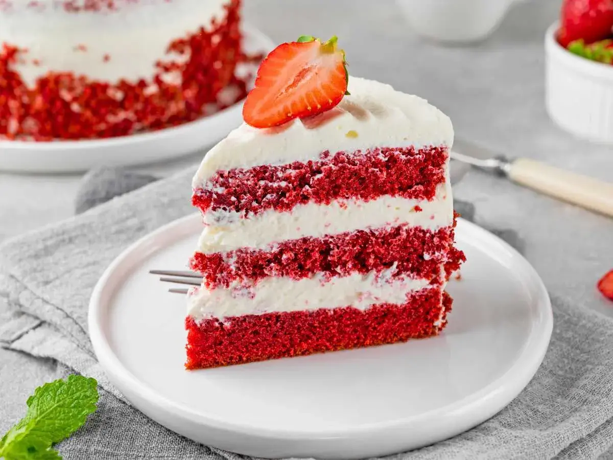 Deliciosa tarta red velvet en capas, cubierta con crema y fresa. Un postre irresistible.