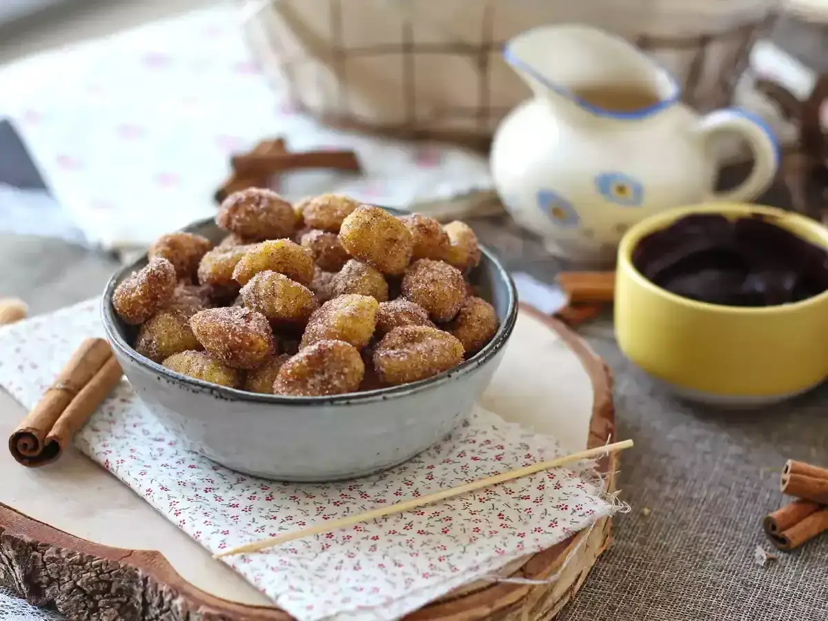 Deliciosos ñoquis en freidora de aire, espolvoreados con azúcar y canela, listos para mojar en chocolate.