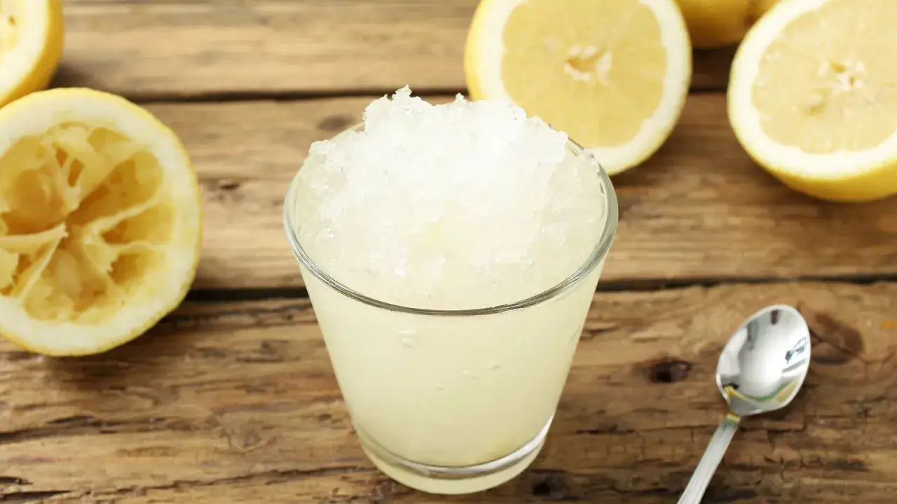 Refrescante granizado de lim&oacute;n, perfecto para un d&iacute;a caluroso. Limones frescos y una cuchara lista para disfrutar.