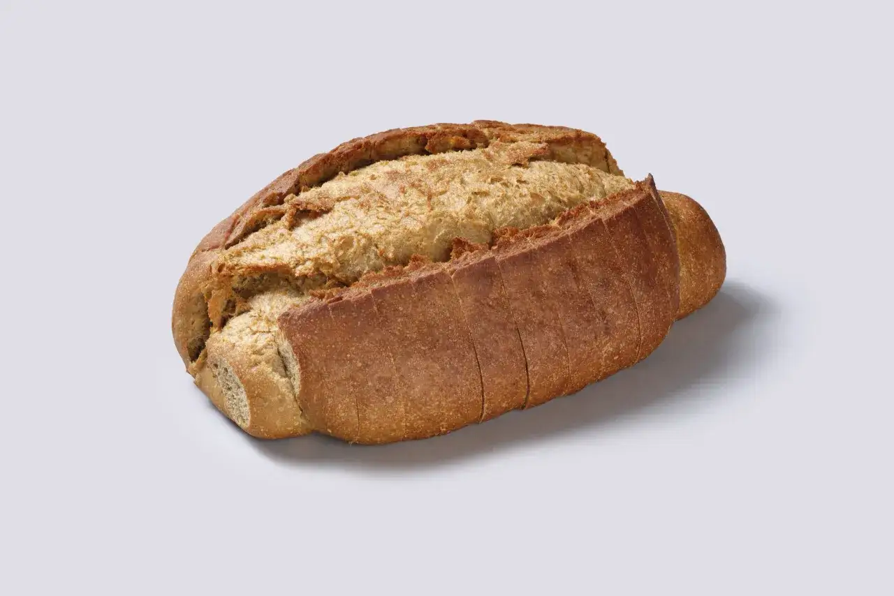 Un pan de centeno rústico, con corteza dorada y miga aireada, cortado en rebanadas.